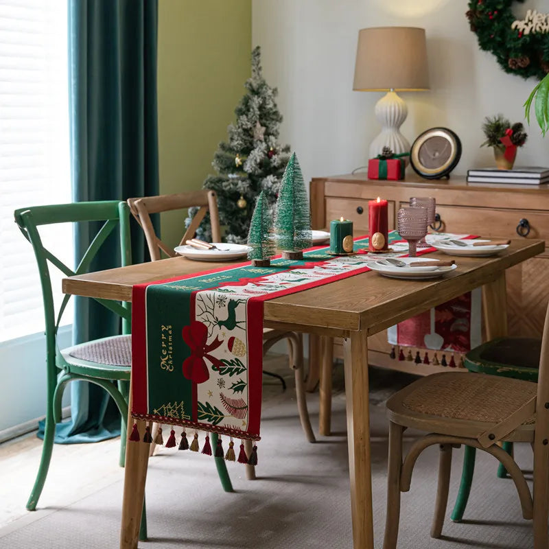 La pièce est décorée pour Noël, avec un arbre de Noël, des bougies rouges, des plats de Noël et une nappe de table avec des motifs de Noël.
