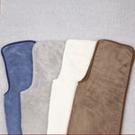 Une variété de tapis de bain aux couleurs neutres et relaxantes, offrant un confort douillet et un style élégant dans la salle de bain.