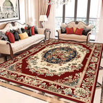 Un tapis oriental richement décoré, avec des motifs floraux traditionnels et des couleurs vives, posé sur un sol de marbre dans un salon élégant meublé de canapés et fauteuils ornés de coussins.
