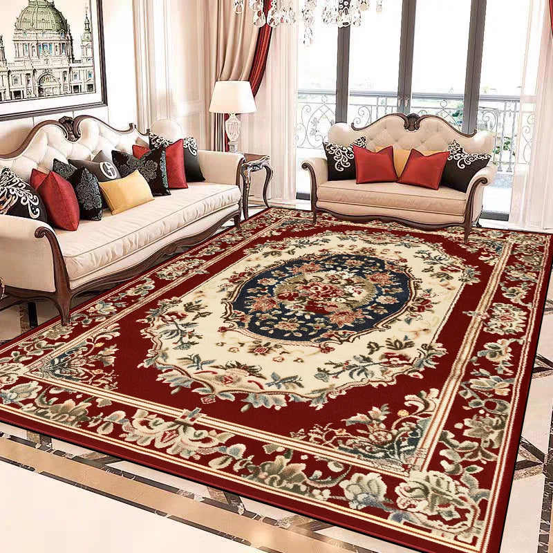 Un tapis oriental richement décoré, avec des motifs floraux traditionnels et des couleurs vives, posé sur un sol de marbre dans un salon élégant meublé de canapés et fauteuils ornés de coussins.