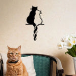 Décoration murale chat en métal noir style japonais suspendue sur un mur blanc