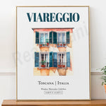 L'image montre un bâtiment traditionnel italien avec des volets verts et des plantes sur les balcons, dans un style aquarelle, avec le texte "Viareggio" et les coordonnées GPS de Toscane, Italie.
