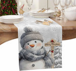 Une table de Noël élégante avec une décoration hivernale et un bonhomme de neige souriant tenant une pancarte "Joyeux Noël".