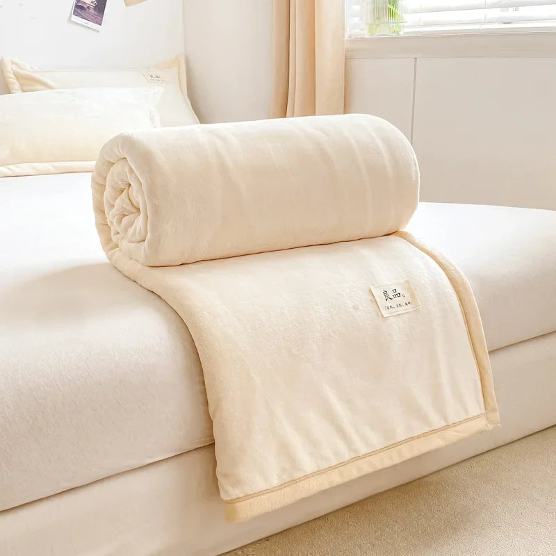Couverture douce et confortable posée sur un canapé beige dans une pièce lumineuse et cosy.