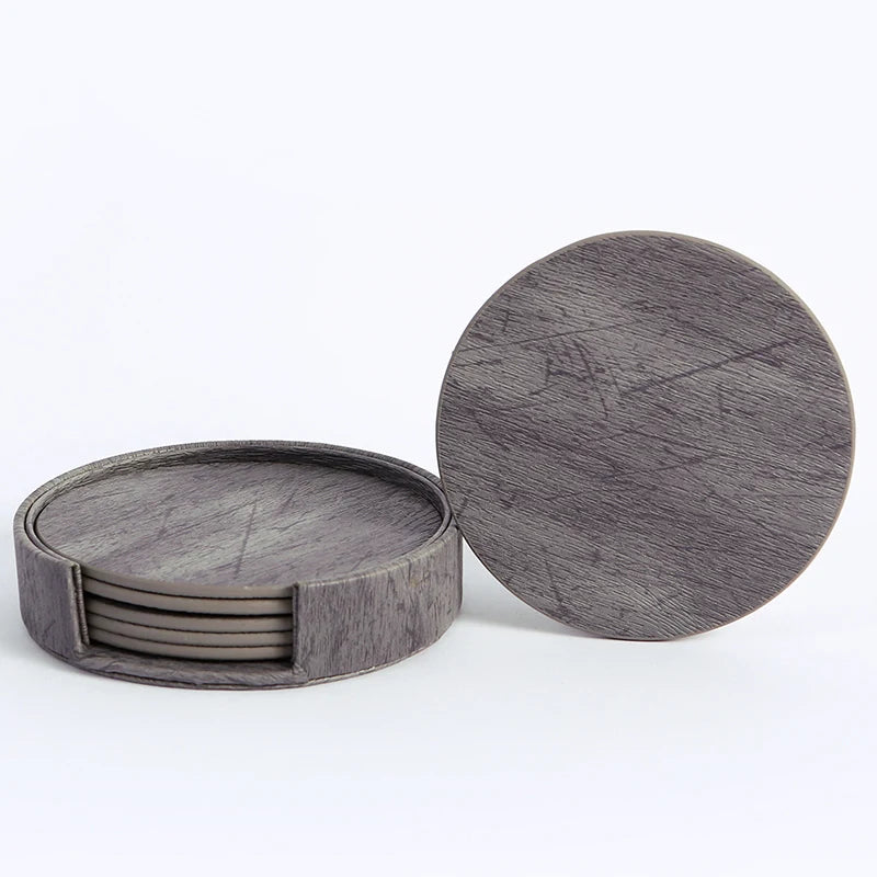 Ensemble de sous-verres ronds en bois de couleur grise avec un motif texturé.