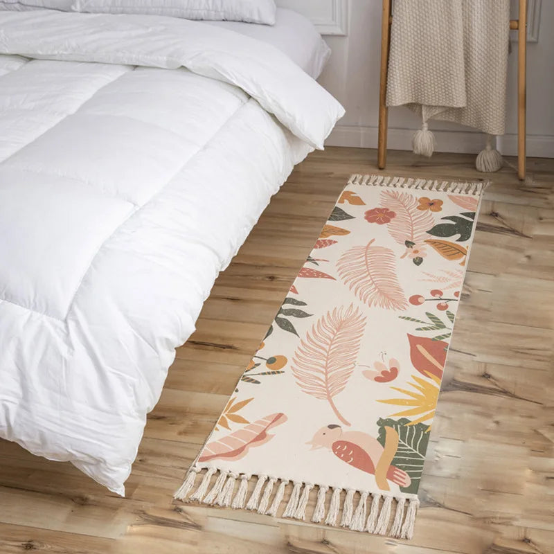 Tapis de sol à motif floral et feuilles colorées, placé à côté d'un lit blanc avec linge de lit.
