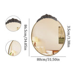 Miroir mural ovale décoratif avec cadre en métal noir et motif de fleurs en relief, offrant une surface réflective pour créer une atmosphère apaisante dans une pièce.