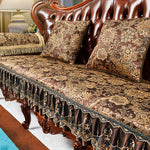 Élégant sofa capitonné aux motifs floraux dorés et ornements en bois sculpté, créant une atmosphère luxueuse et raffinée dans cette pièce.