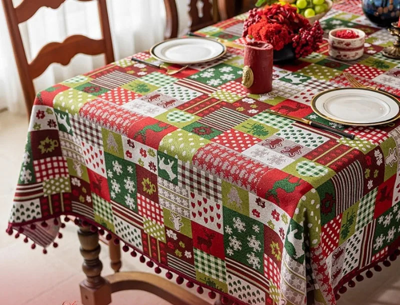 Une nappe de table aux motifs de Noël multicolores, avec des éléments festifs comme une composition florale rouge, crée une ambiance chaleureuse et joyeuse pour la période des fêtes.