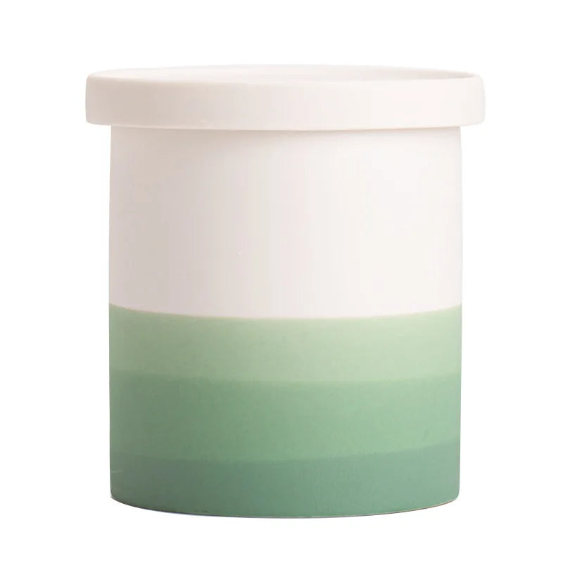 Pot de plantes bicolore blanc et vert pastel, avec un couvercle, utilisé pour ranger ou exposer des objets décoratifs.