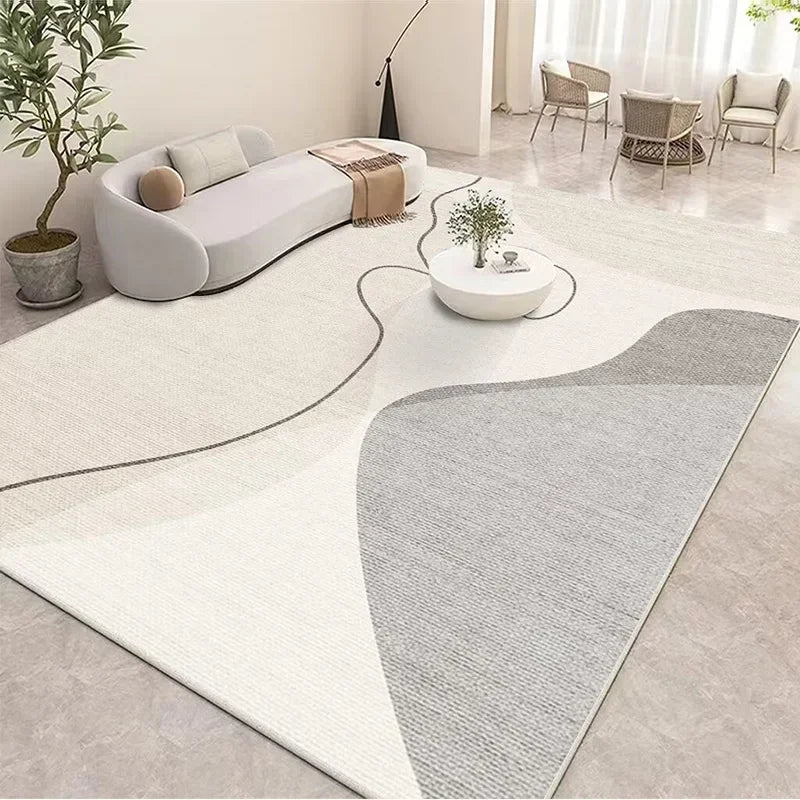 Un espace de vie moderne et épuré, avec un canapé blanc aux formes arrondies, une table basse blanche et des fauteuils en rotin, le tout agrémenté de plantes vertes et de touches de beige et de gris.