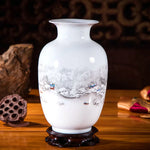 Un vase en porcelaine blanche orné d'un motif paysager enneigé représentant une scène hivernale sereine avec de petites embarcations sur un lac.