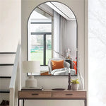 Une zone d'entrée élégante avec un miroir rond, un meuble de rangement en bois et des décorations modernes, créant une atmosphère accueillante et raffinée.