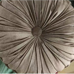Coussin rond vert en forme de citrouille utilisé comme pouf de sol