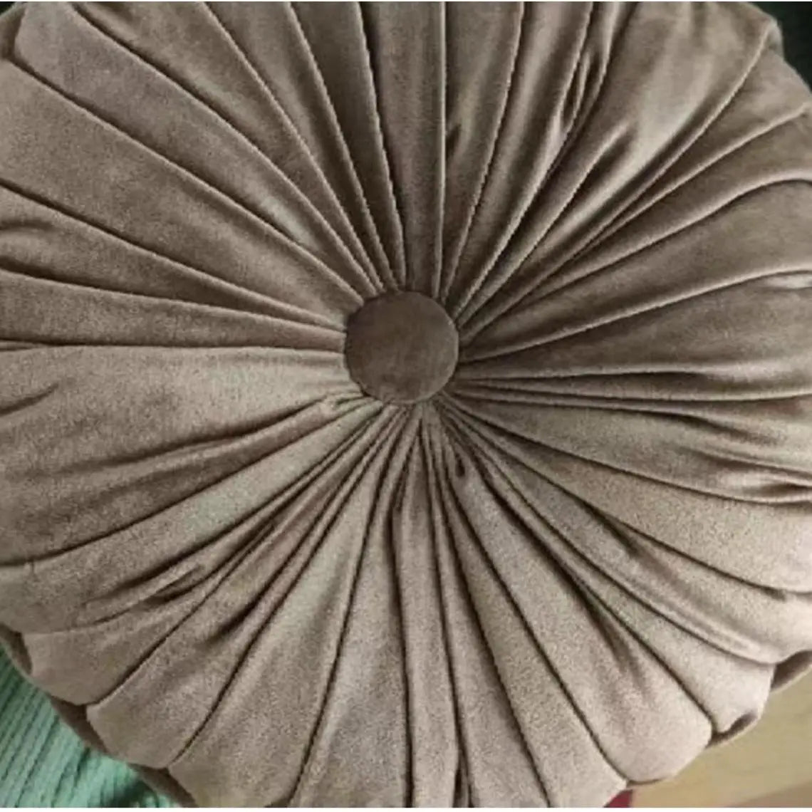 Coussin rond vert en forme de citrouille utilisé comme pouf de sol