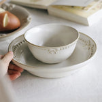Bol et assiette en céramique blanche ornés de motifs floraux.