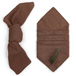 Serviette de table brun foncé avec un motif de branche verte.