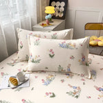 Des coussins aux motifs floraux et de lapins, sur un lit avec une lampe jaune et des éléments de décoration, créant une atmosphère chaleureuse et accueillante dans la pièce.