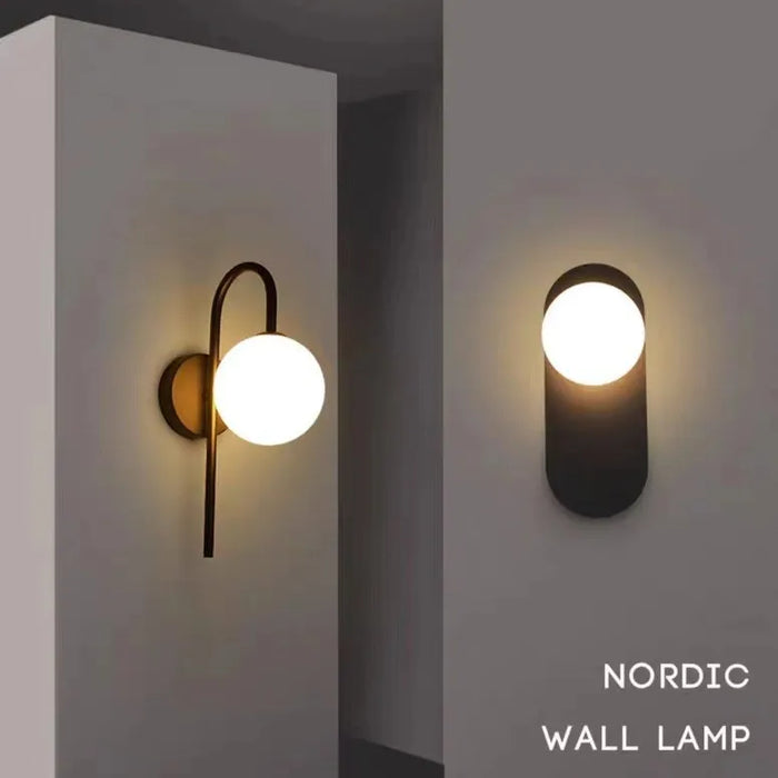 Applique murale dorée avec boule en verre laiteux sur mur blanc