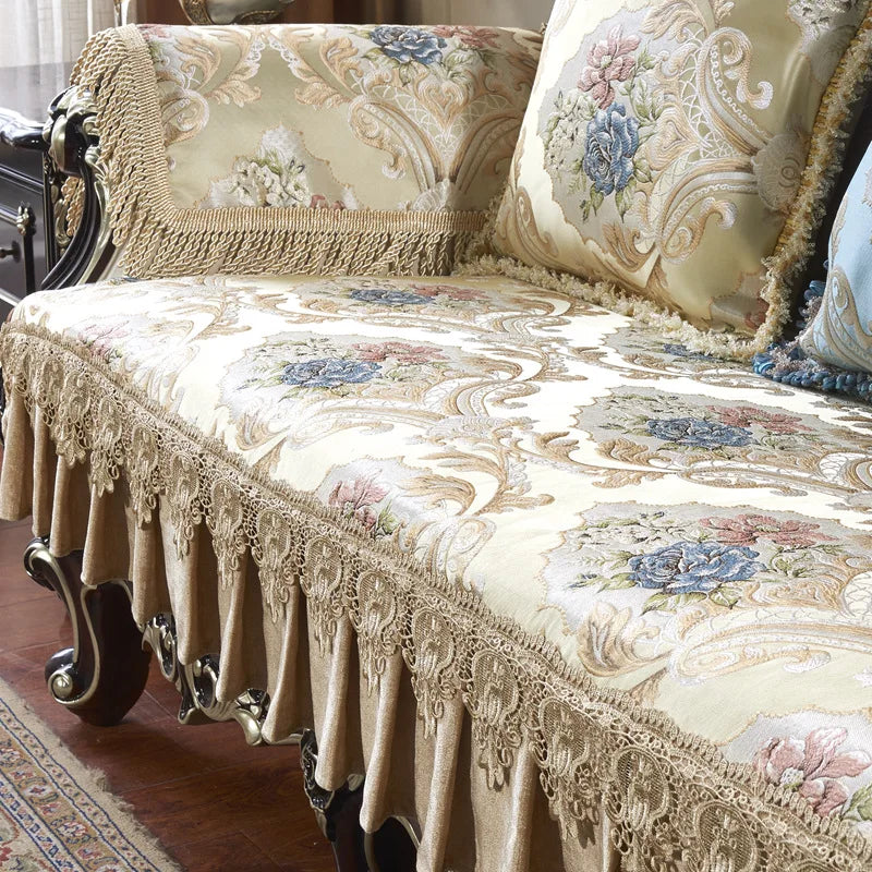 Fauteuil élégant avec un riche motif floral et des bordures à franges dans des tons crème, beige et bleu.