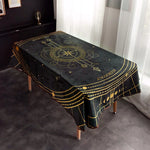 Cette nappe noire et dorée, ornée de motifs astrologiques, crée une ambiance mystique et élégante dans la pièce.