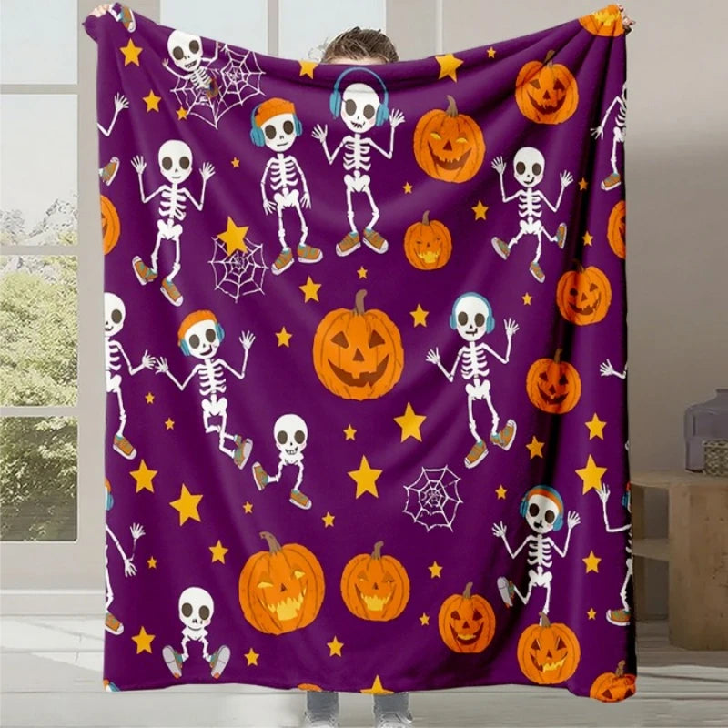 Cette image montre un plaid décoratif de couleur violette avec des motifs d'Halloween, tels que des squelettes, des citrouilles effrayantes et des toiles d'araignée, créant une ambiance festive et amusante.
