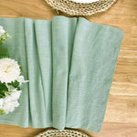 Chemin de table vert sapin sur une table basse avec décorations festives