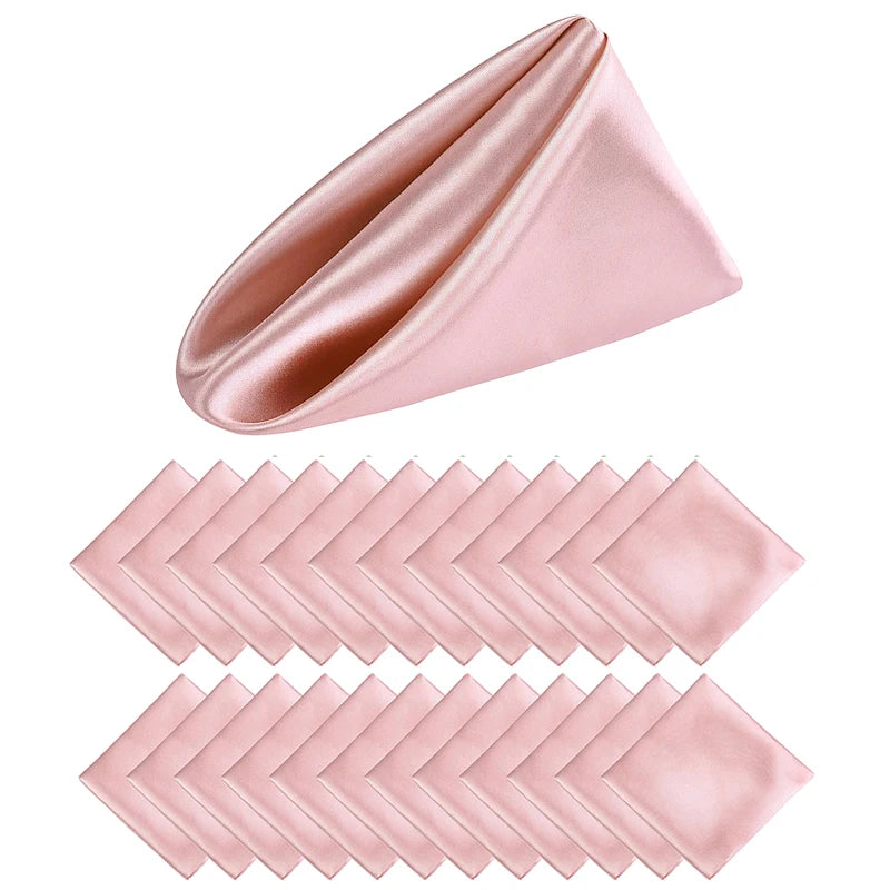 Serviettes de table roses en satin, pliées et empilées, avec un motif diagonal élégant.