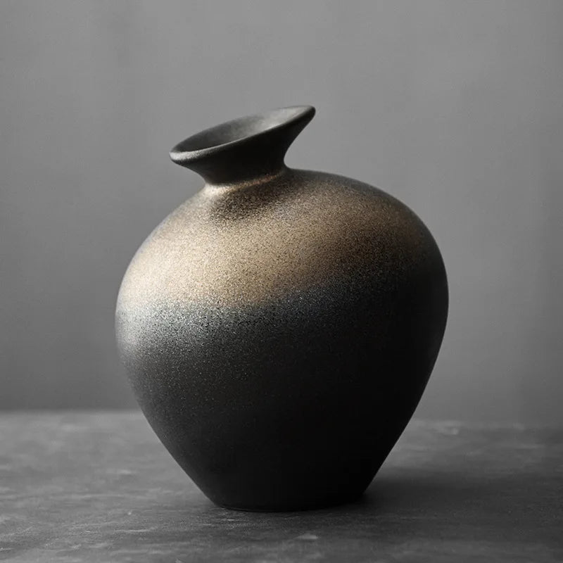 Vase en terre cuite noir imitation pierre sur table en bois