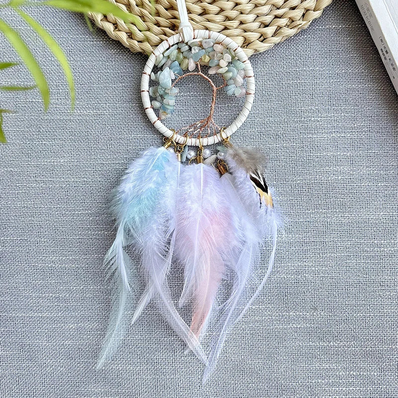 Une belle attrape-rêves artisanale suspendue sur un fond vert, avec des plumes douces et délicates qui s'entrelacent dans un design élégant et apaisant.