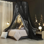 Une chambre à coucher mystérieuse et fantastique, avec un lit à baldaquin noir scintillant et des accessoires décoratifs donnant une ambiance chaleureuse et accueillante.