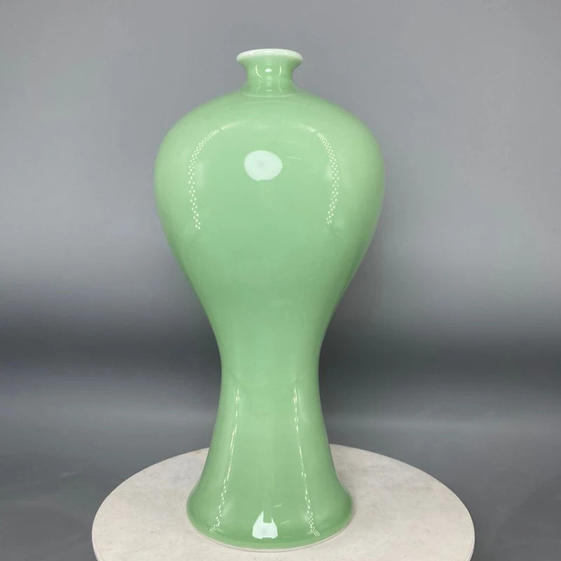 Vase de céramique vert clair de forme élégante et épurée, avec un design minimaliste qui met en valeur la beauté de la matière.