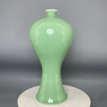 Vase de céramique vert clair de forme élégante et épurée, avec un design minimaliste qui met en valeur la beauté de la matière.