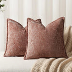 Des coussins en velours brun, texturés et confortables, posés sur un canapé, créant une ambiance chaleureuse et apaisante dans un décor neutre.