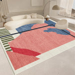 Tapis géométrique multicolore avec des formes abstraites en bleu, rose et rouge posé dans un intérieur lumineux et épuré.