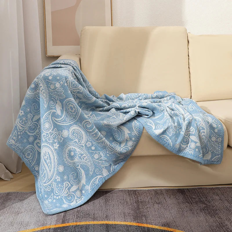 Une couverture douce et paisible ornée d'un motif cachemire bleu clair, une belle décoration pour un intérieur cosy.