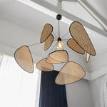 Suspension luminaire rotin japonais suspendue au plafond dans un salon moderne
