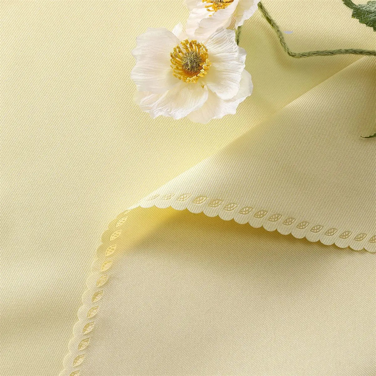 Une délicate fleur blanche avec des pétales ondulés et un cœur doré sur un fond doux et crémeux.