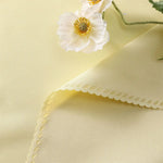Une délicate fleur blanche avec des pétales ondulés et un cœur doré sur un fond doux et crémeux.
