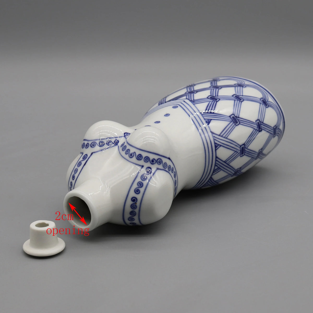 Un vase de style japonais élégamment décoré de motifs en damier bleu et blanc avec une ouverture de 2 cm.