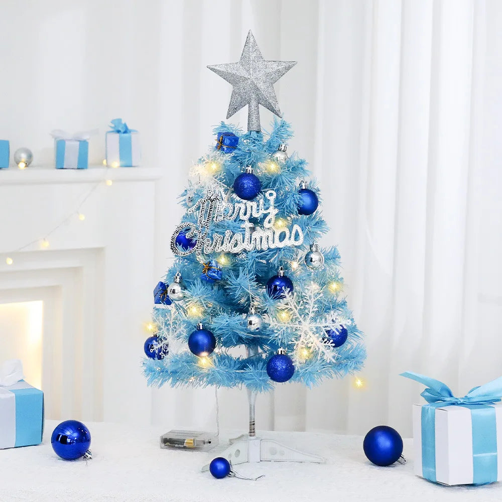 Mini sapin de Noël bleu avec lumières sur un bureau