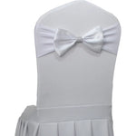 Cette image montre une chaise recouverte de blanc, avec un nœud papillon orné de cristaux au centre du dossier.