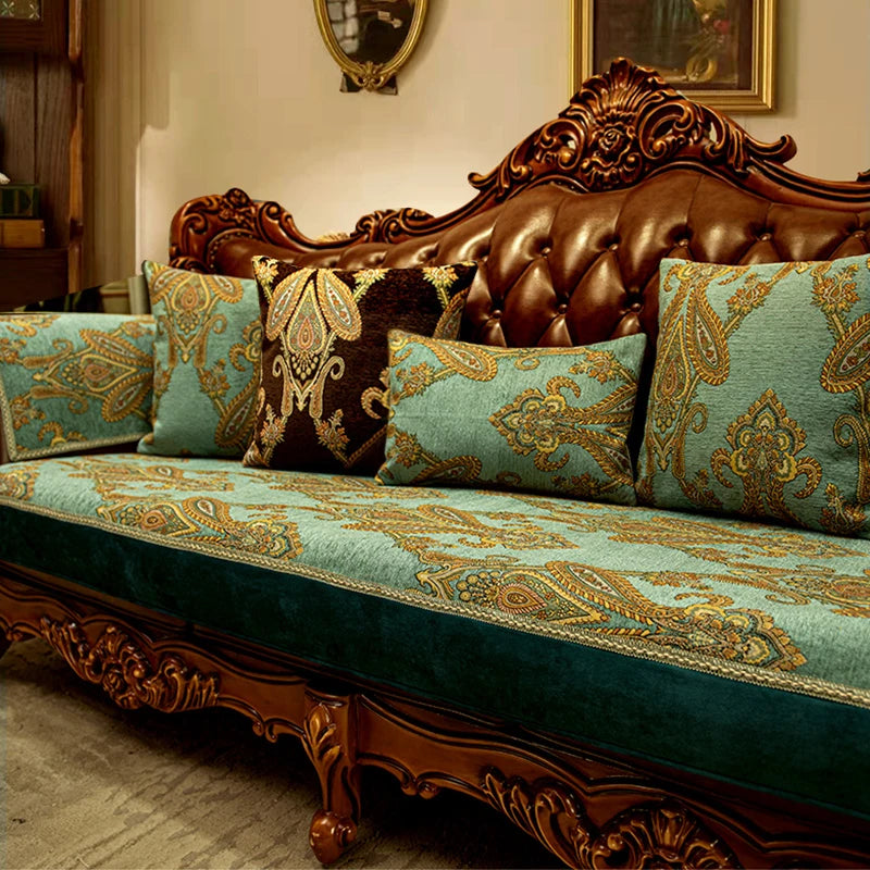 Ce canapé ancien en bois richement sculpté est recouvert de coussins décoratifs aux motifs et couleurs luxueux, créant une atmosphère élégante et raffinée dans la pièce.