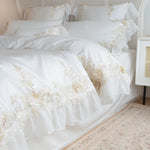 Parure de lit blanche en dentelle brodée de luxe sur un lit king-size