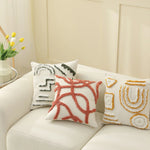 Des coussins décoratifs avec des motifs abstraits et colorés ajoutent une touche personnelle et chaleureuse à ce salon confortable.