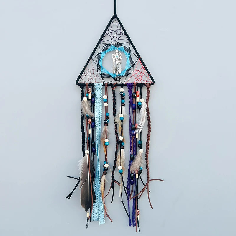 Un capteur de rêves décoratif en forme de triangle, orné de plumes, de perles et de rubans colorés qui pendent pour créer une atmosphère apaisante et mystique.