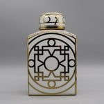 Cette image montre un vase décoratif en porcelaine blanche et or avec des motifs géométriques complexes.