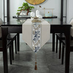 Une élégante table de salle à manger avec un chemin de table décoratif, un bonsaï et des accessoires de style asiatique.