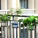 Jardinière rouge avec plante retombante sur balcon moderne