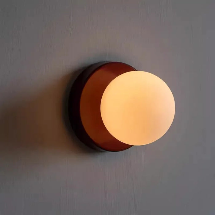 Applique murale boule de verre LED noire sur mur blanc